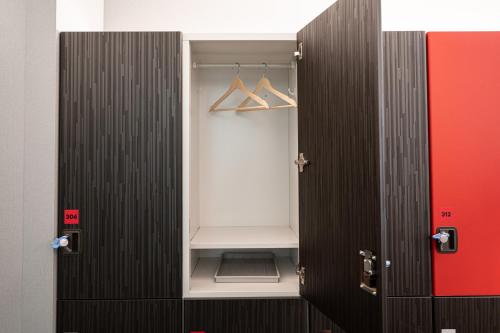 a walk in closet with a black door and hangers at NINJA & GEISHA in Osaka