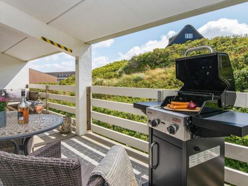 a grill on a patio with a table and a table at 6 person holiday home in Ringkøbing-By Traum in Ringkøbing