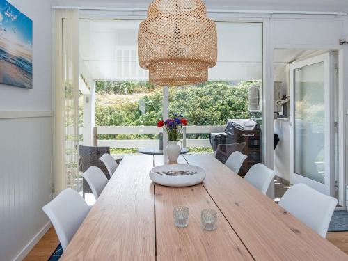 a dining room with a wooden table and white chairs at 6 person holiday home in Ringkøbing-By Traum in Ringkøbing