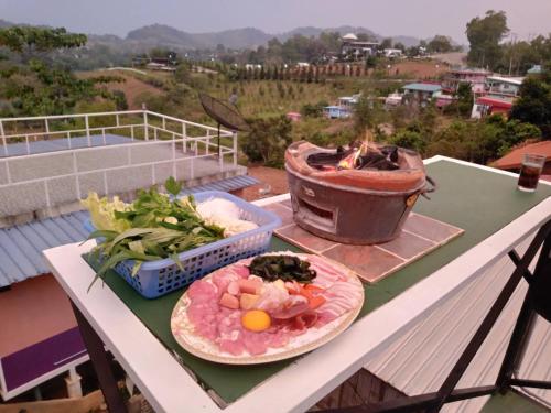 una mesa con dos platos de comida en una parrilla en โดม มองโก แสงเพ็ญ, en Khao Kho