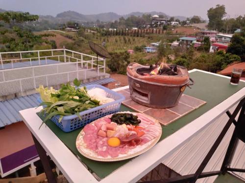 une table avec deux assiettes de nourriture sur un grill dans l'établissement โดม มองโก แสงเพ็ญ, à Khao Kho