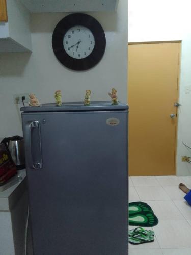 a clock on the wall above a refrigerator in a kitchen at Guest House in Cainta Rizal in Cainta