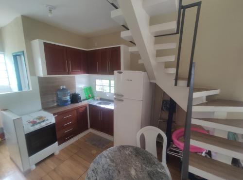 uma cozinha com uma escada em espiral numa cozinha em Casas Aconchego do Mar em Japaratinga