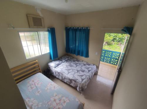 um pequeno quarto com 2 camas e uma janela em Casas Aconchego do Mar em Japaratinga