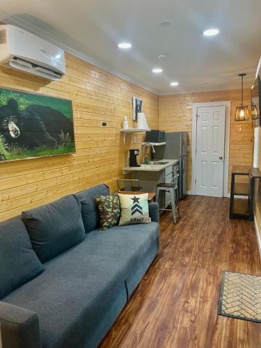 a living room with a blue couch and a kitchen at Camptel Poconos in Albrightsville