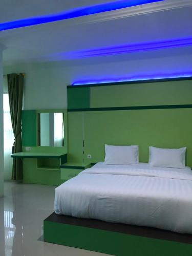a bedroom with a large white bed with blue lights at Shaima Homestay Syari'ah in Bukittinggi