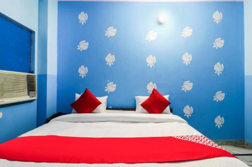 a bedroom with blue walls and a bed with red pillows at OYO Hotel Moon Tara in Faridabad