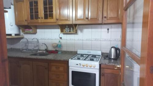 a kitchen with wooden cabinets and a white stove top oven at Departamento Quinta Sección in Mendoza