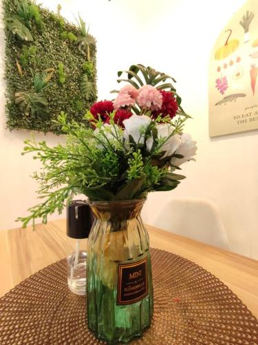 a glass vase with flowers in it on a table at Mini Green Homestay in Kulai