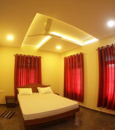 a bedroom with a bed with red curtains at Meghdoot river resort in Cochin