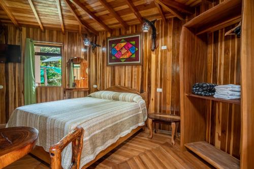 - une chambre avec un lit et un vitrail dans l'établissement Casitas del Bosque Monteverde., à Monteverde Costa Rica