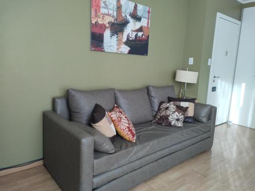 a gray couch with pillows on it in a living room at My Place Buenos Aires in Buenos Aires