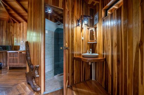 a wooden bathroom with a sink and a shower at Casitas del Bosque Monteverde. in Monteverde Costa Rica