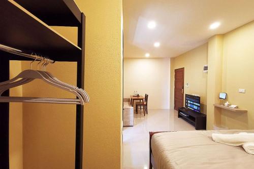 a bedroom with a bunk bed and a living room at The Middle Town SHA in Chiang Rai