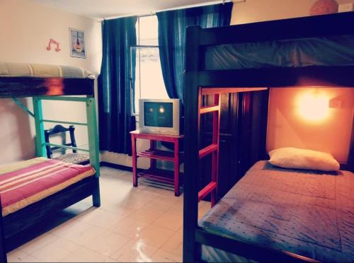 a bedroom with two bunk beds and a television at Flying Donkey in Otavalo