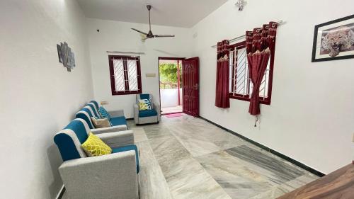 a living room with two chairs and a couch at WHITE HOUSE - 3BHK Elite Apartment in Coimbatore