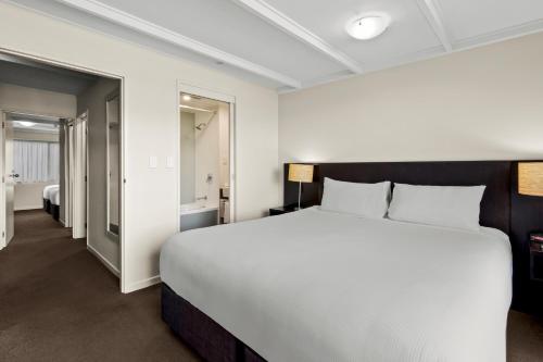 a bedroom with a large bed and a bathroom at Copthorne Hotel & Apartments Queenstown Lakeview in Queenstown