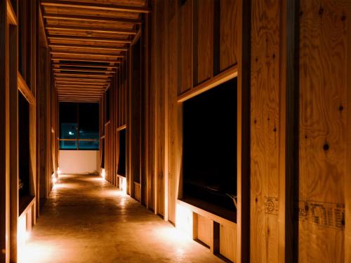 a hallway of a building with wooden walls at WhyKumano in Nachikatsuura