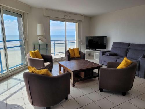un salon avec un canapé, des chaises et une télévision dans l'établissement Magnifique Appartement Face Mer avec 2 Balcons, Terrasse et Ascenseur - FR-1-672-4, à Merlimont