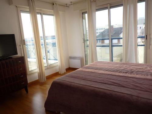 - une chambre dotée de fenêtres, d'un lit et d'une télévision dans l'établissement Magnifique Appartement Face Mer avec 2 Balcons, Terrasse et Ascenseur - FR-1-672-4, à Merlimont