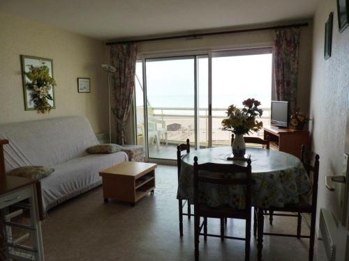 un salon avec une table et un canapé dans l'établissement Appartement 4 pers avec parking, ascenseur et local vélos à Merlimont - FR-1-672-11, à Merlimont