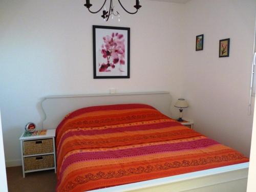 une chambre avec un lit avec une couverture orange dans l'établissement Appartement cosy avec balcon et vue sur lac à Merlimont - FR-1-672-8, à Merlimont