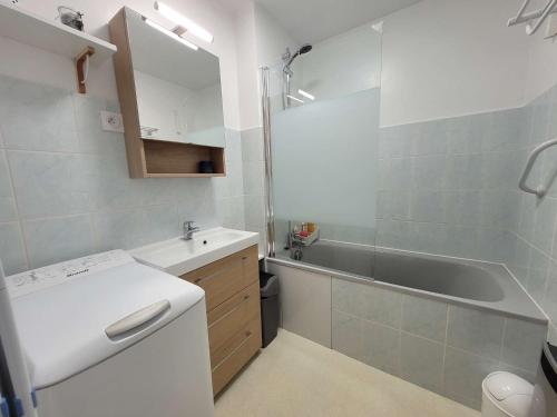 La salle de bains est pourvue d'un lavabo, d'une baignoire et de toilettes. dans l'établissement Appartement cosy face mer avec balcon et parking privé - FR-1-672-13, à Merlimont