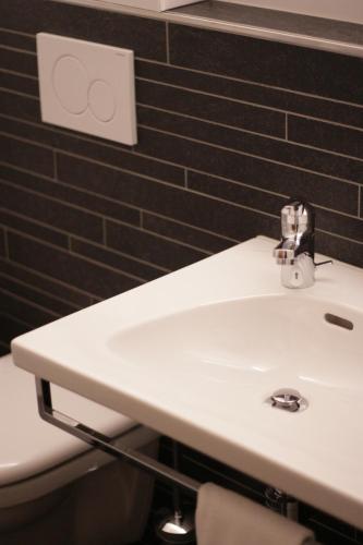 a bathroom with a white sink and a toilet at Hotel Eremitage in Arlesheim