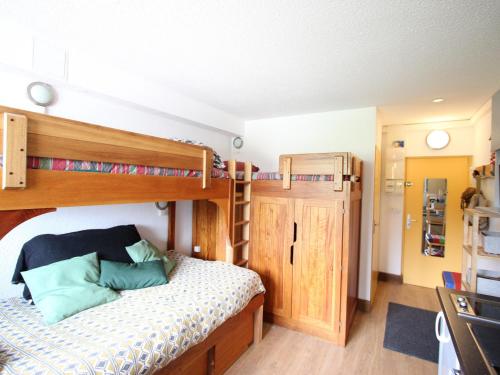 a bedroom with two bunk beds and a kitchen at Studio Chamrousse, 1 pièce, 3 personnes - FR-1-549-95 in Chamrousse