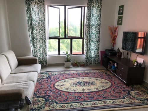 a living room with a couch and a rug at Roomstay in Putrajaya (Female only/Queen bed) in Kampong Batu Sembilan