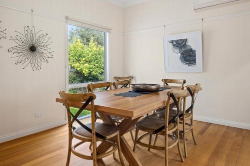 a dining room with a wooden table and chairs at Yarra Gables in Healesville