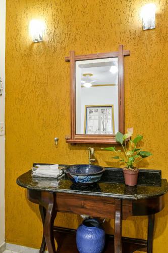 a bathroom with a sink and a mirror at Pousada da Tina in Ubatuba