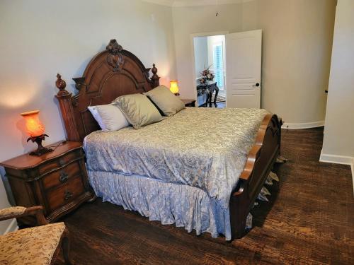 a bedroom with a large bed with a wooden headboard at Newly Renovated Private Ranch Get-A-Way in Pilot Point