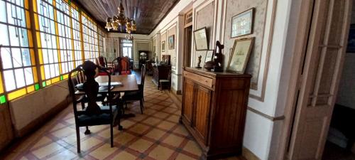 a dining room with a table and chairs and windows at La Casona 1870 in Godoy Cruz