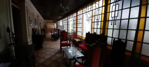 a room with chairs and a table and windows at La Casona 1870 in Godoy Cruz
