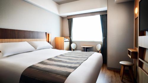 um quarto de hotel com uma cama e uma janela em Hotel Monte Hermana Tokyo em Tóquio