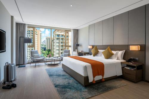 1 dormitorio con cama grande y ventana grande en Oakwood Premier Phnom Penh, en Phnom Penh