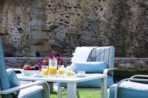 - une table avec des verres de jus d'orange sur une terrasse dans l'établissement La Riguera de Ginio, à Ucieda de Arriba