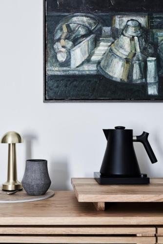 a table with two lamps and a painting on the wall at Hotel Ernest Bendigo in Bendigo