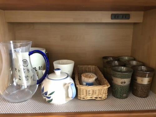 a shelf with a vase and baskets on it at Kantan the house with ocean view in Oita