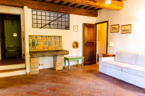 a living room with a white couch and a fireplace at Podere Mezzastrada - Place of Charme in Fiano