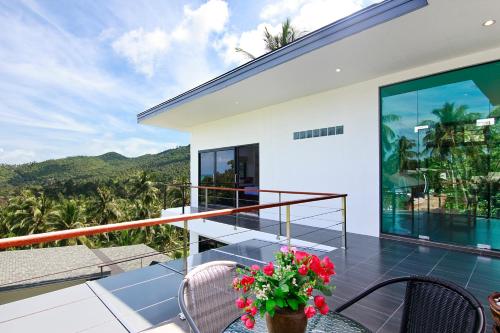 a balcony with a view of a house at 2 Bays Villa in Thong Nai Pan Yai