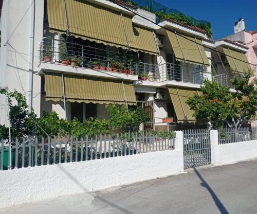 a white fence in front of a building at Villa Froso in Pefki