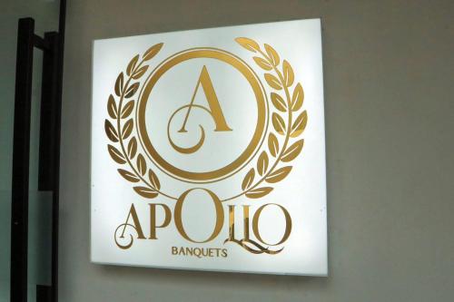 a sign for a apollo brands hanging on a wall at Mastiff Hotel Ankleshwar in Ankleshwar