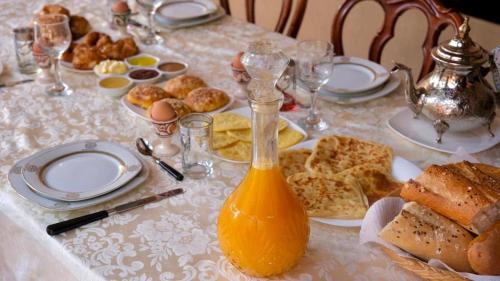uma mesa com um pequeno-almoço de ovos pão e sumo de laranja em Riad Benyara em Tarudante