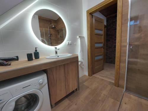 Domek/apartament Przekop في سروموس وايزين: حمام مع مغسلة وغسالة ملابس