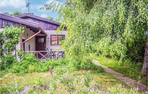 an old house with a tree and a yard at Stunning Home In Ljungbyholm With Sauna in Ljungbyholm