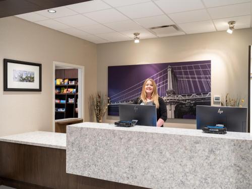 a woman standing behind a counter in an office at Staybridge Suites - Sioux City Southeast by IHG in Sioux City