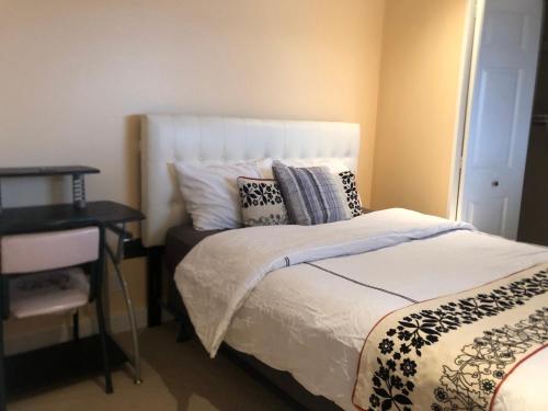 a bedroom with a bed with pillows and a table at citadel hills valley in Calgary