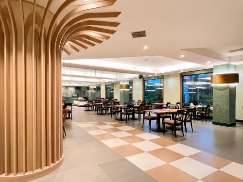 restauracja ze stołami i krzesłami oraz podłogą wyłożoną szachownicą w obiekcie Uni-Resort Mawutu w mieście Guanxi